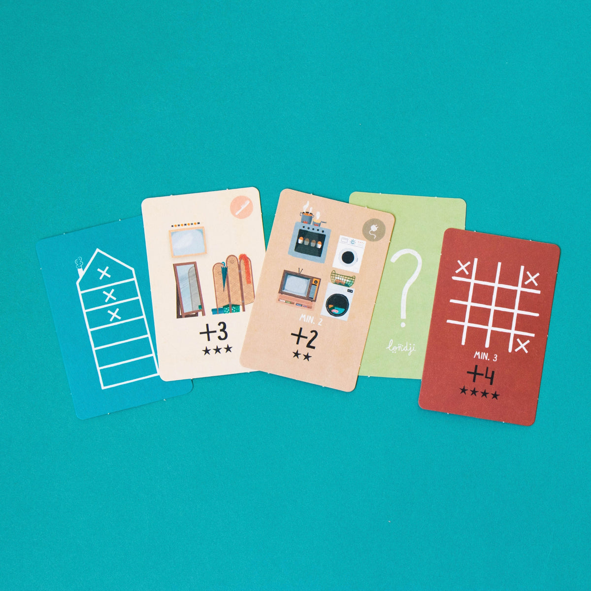 Four colorful cards arranged in a fan shape on a solid teal background. The cards feature different illustrations and text such as '+3', '+2', a question mark, and a tic-tac-toe board game.