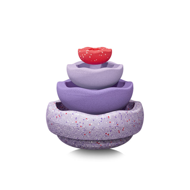 A set of four nested, scallop-edged Stapelstein pieces in shades of purple with a speckled texture, topped with a small red piece on a white background.