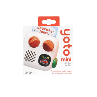 Yoto Mini portable audio player in its retail packaging, featuring a white body with orange circular buttons, a green side button, and a small train graphic on the pixel screen.